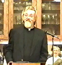 Father Sandell standing at microphone.